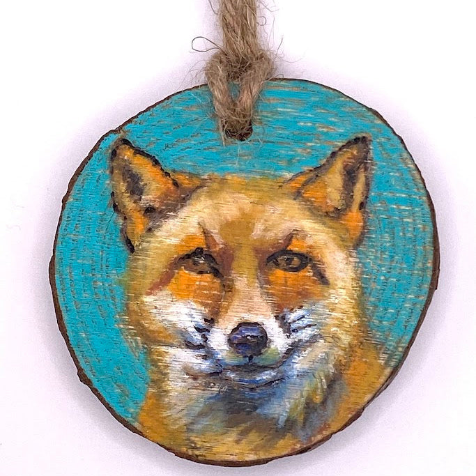 Wooden ornament with a fox face design on a white background