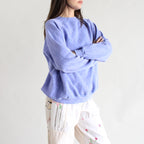 Person wearing a light blue sweater with a plain background