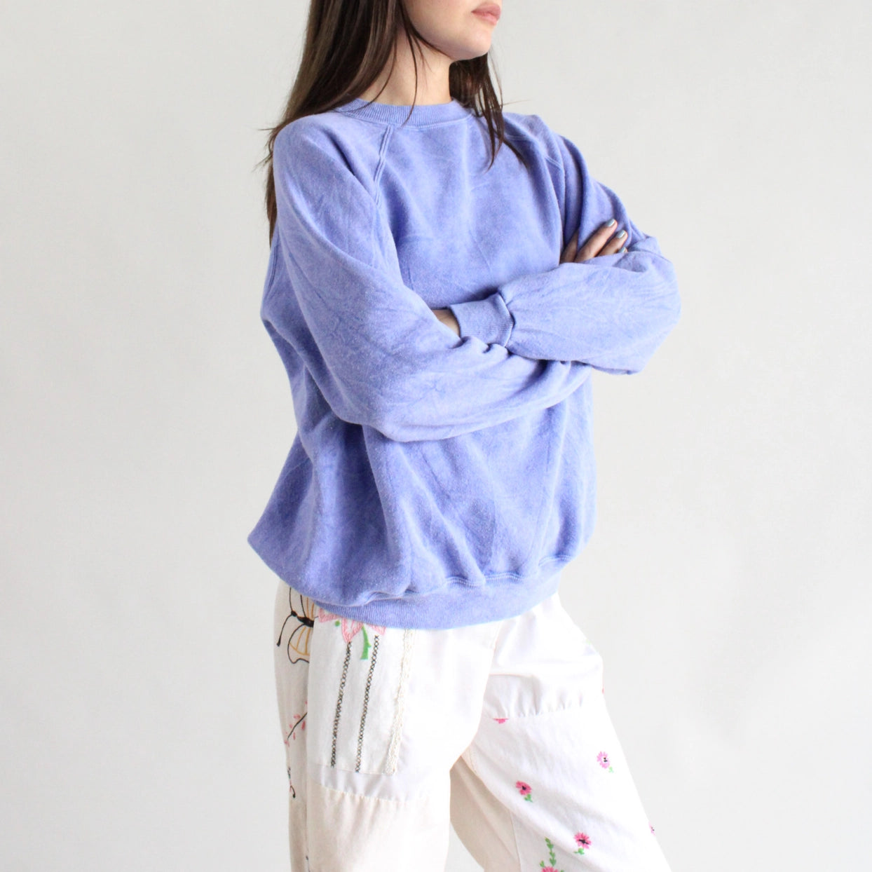 Person wearing a light blue sweater with a plain background