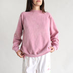 Person wearing a pink sweatshirt against a plain background