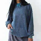 Person wearing a blue hoodie and gray sweatpants against a white background
