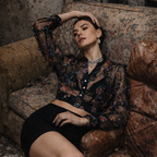 Woman sitting on a vintage couch in a dimly lit room
