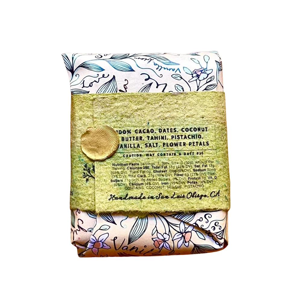 A packaged food product wrapped in a floral patterned cloth and tied with a textured olive-green paper band featuring a gold wax seal, shown on a plain white background.