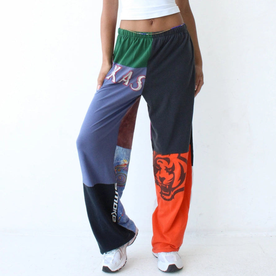 Person wearing colorful patchwork pants with a white top on a white background