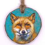 Wooden ornament with a fox face design on a white background