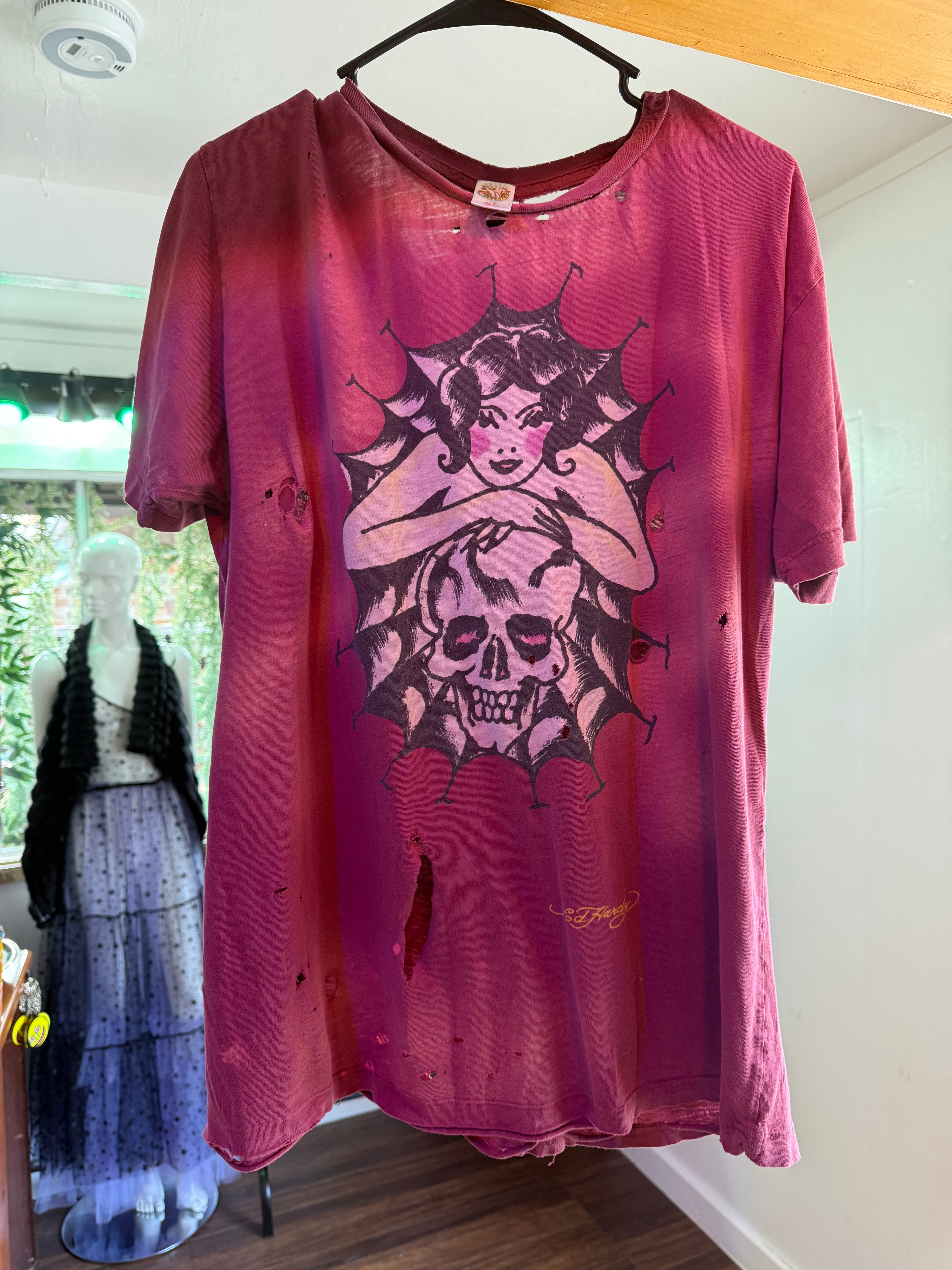 Shop our authentic thrashed vintage Y2K Ed Hardy t-shirt. Features a distressed spiderweb skull graphic, heavy sun-fading, and a classic yellow back logo.