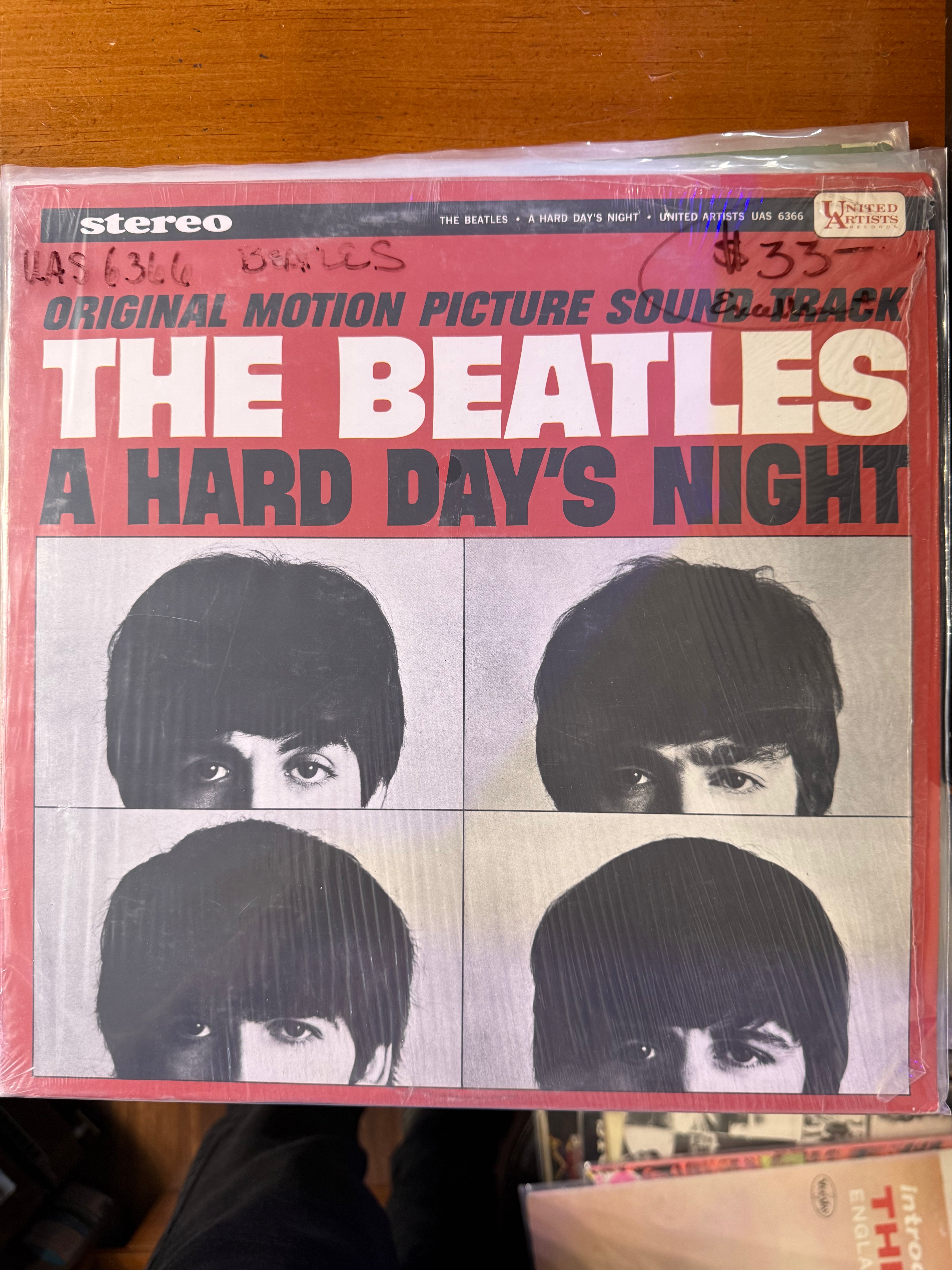 Front jacket cover of The Beatles A Hard Day's Night original motion picture soundtrack vinyl album on United Artists, featuring bold pink and gray title typography above four close-up black-and-white portraits of John, Paul, George, and Ringo.
