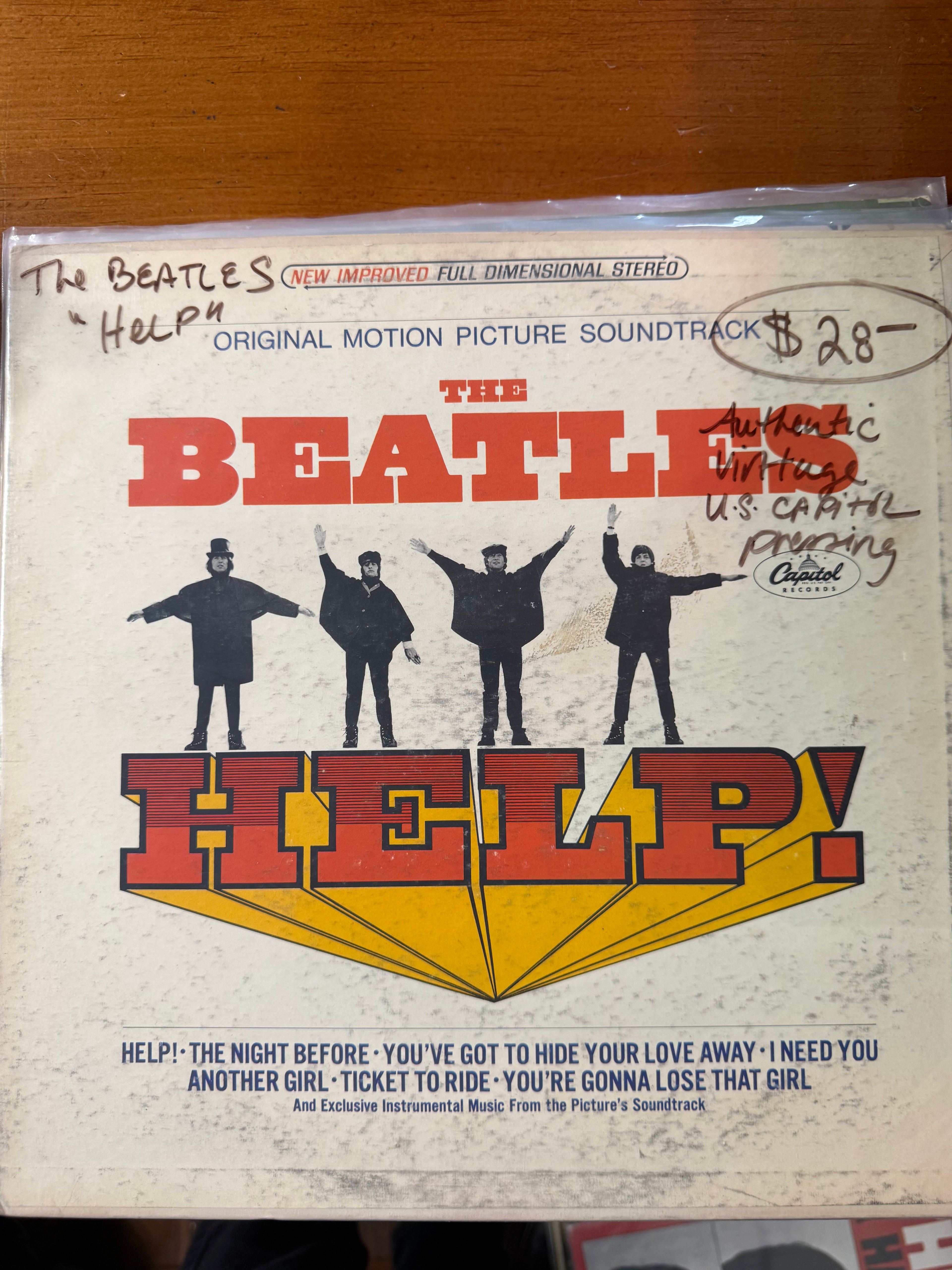 Front jacket cover of The Beatles Help! original motion picture soundtrack vinyl LP on Capitol Records, featuring John, Paul, George, and Ringo posing in dark coats against a white background with bold red and yellow title typography.