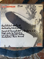 Vintage vinyl record cover for Led Zeppelin's self-titled debut album featuring a graphic black-and-white illustration of the Hindenburg airship exploding, with bold orange top lettering and Atlantic Records logo SD 8216.