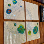Four abstract artworks on a wooden surface
