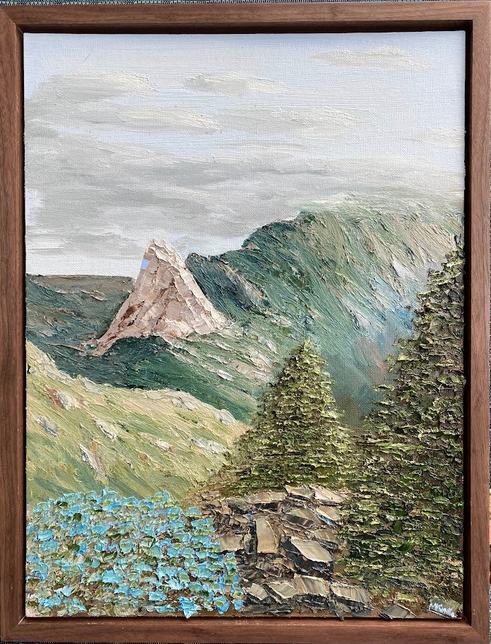 Painting of a mountain landscape with trees and flowers, framed in brown.