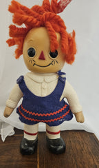 alt="Vintage Raggedy Ann doll with molded face, orange yarn hair, and blue felt jumper dress with red ric-rac trim"